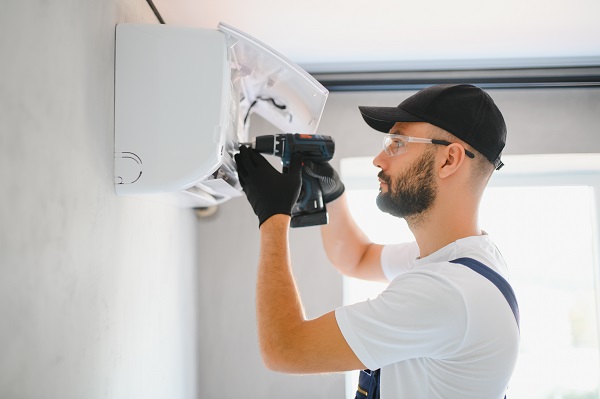 Tecnico si occupa della riparazione di condizionatori.